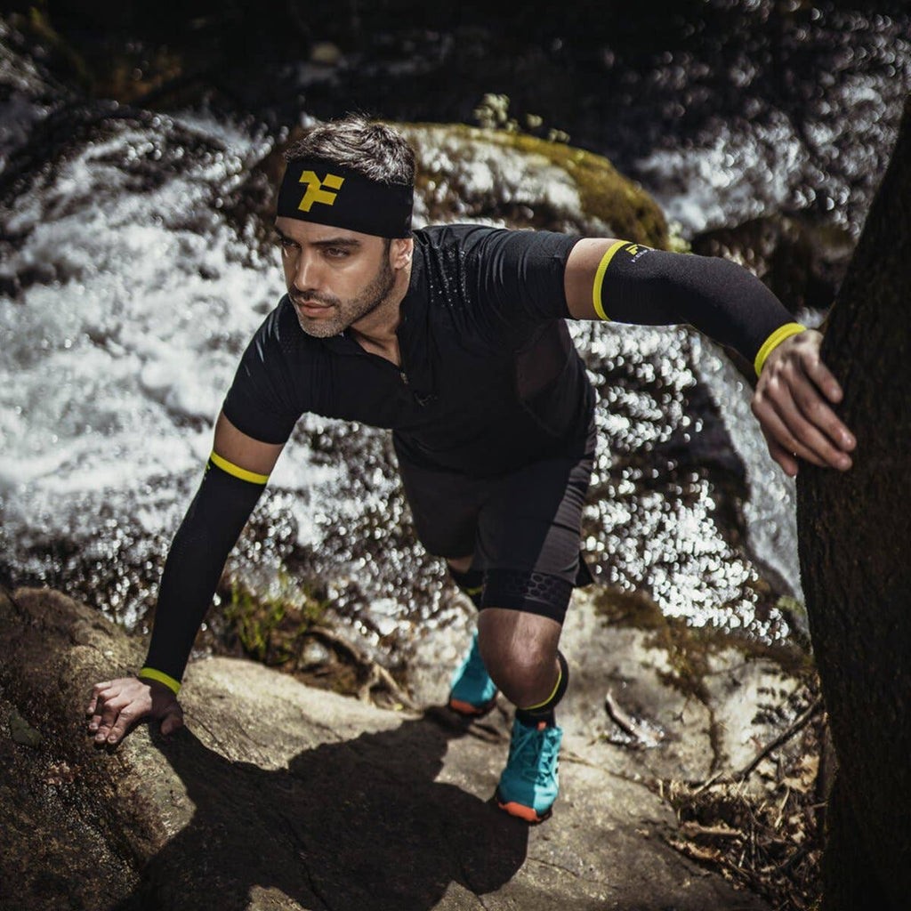 Men med pannband som klättrar på klippor 