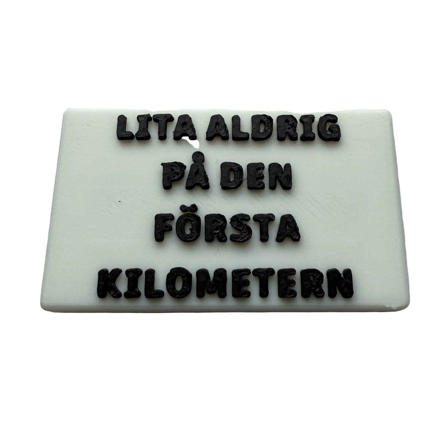 Kylskåpsmagnet med vit bas och svart text