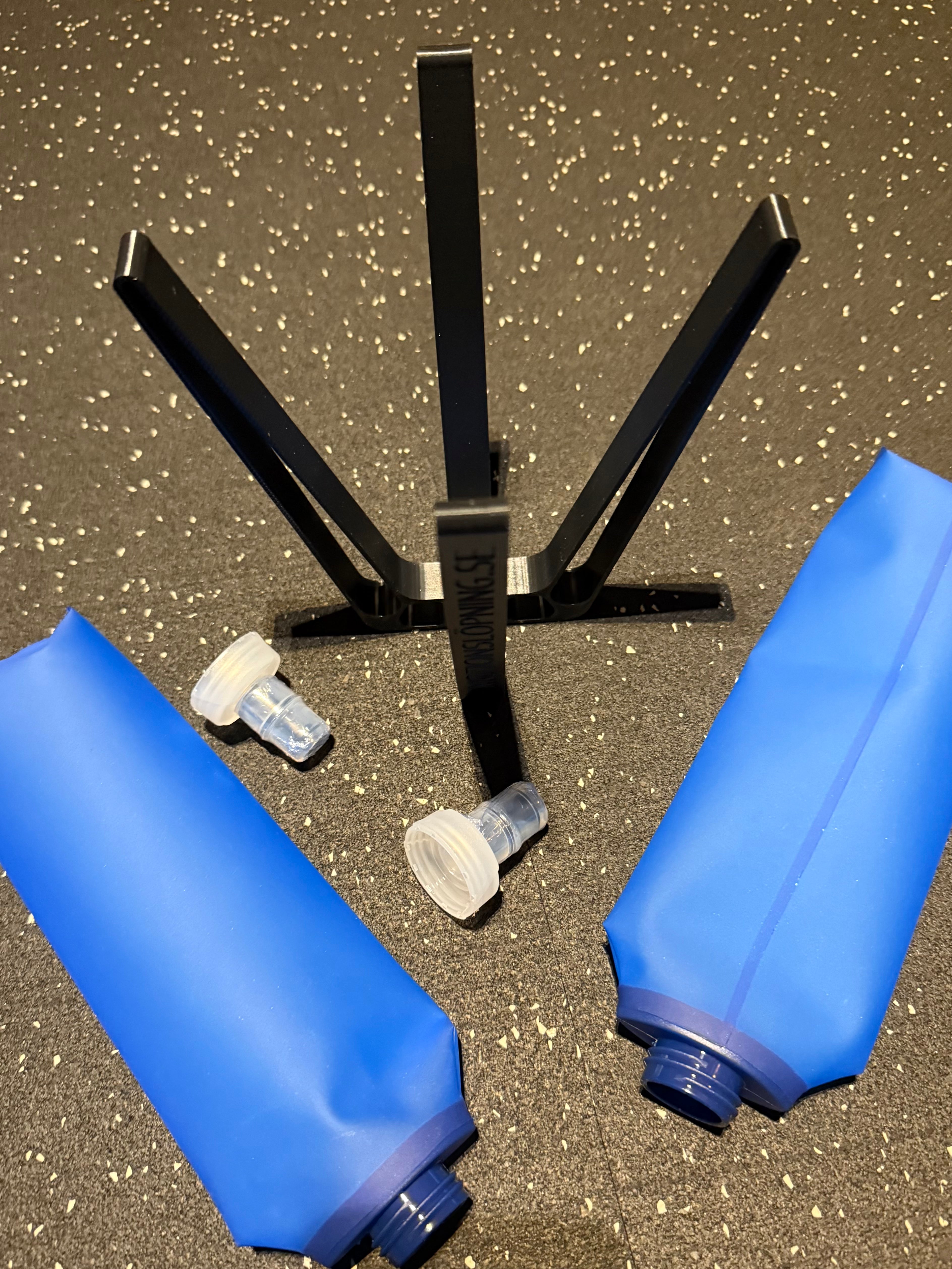 Två blåa vattenflaskor och ett torkställ