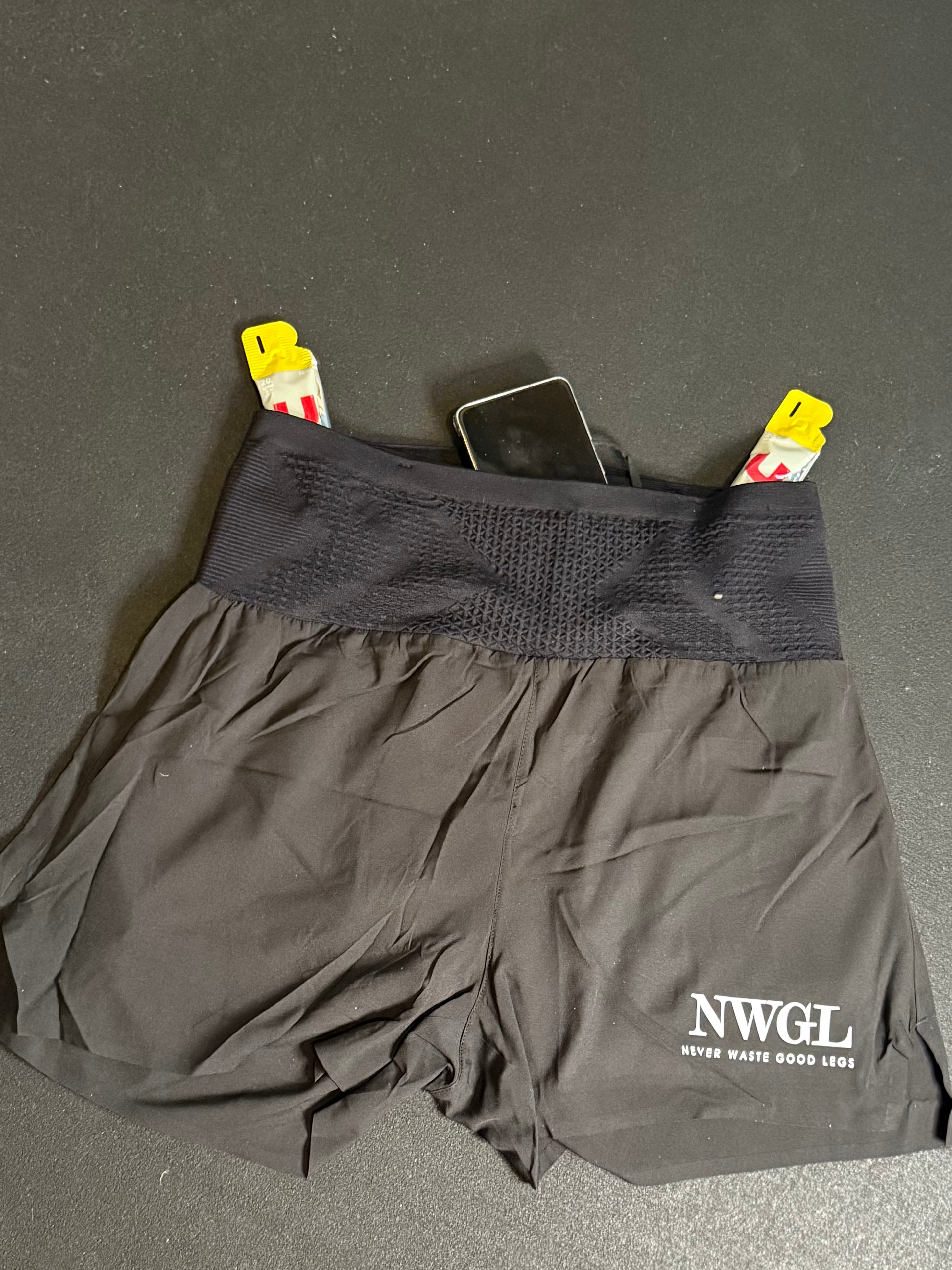 Svarta shorts, märke NWGL med två gels och en mobiltelefon