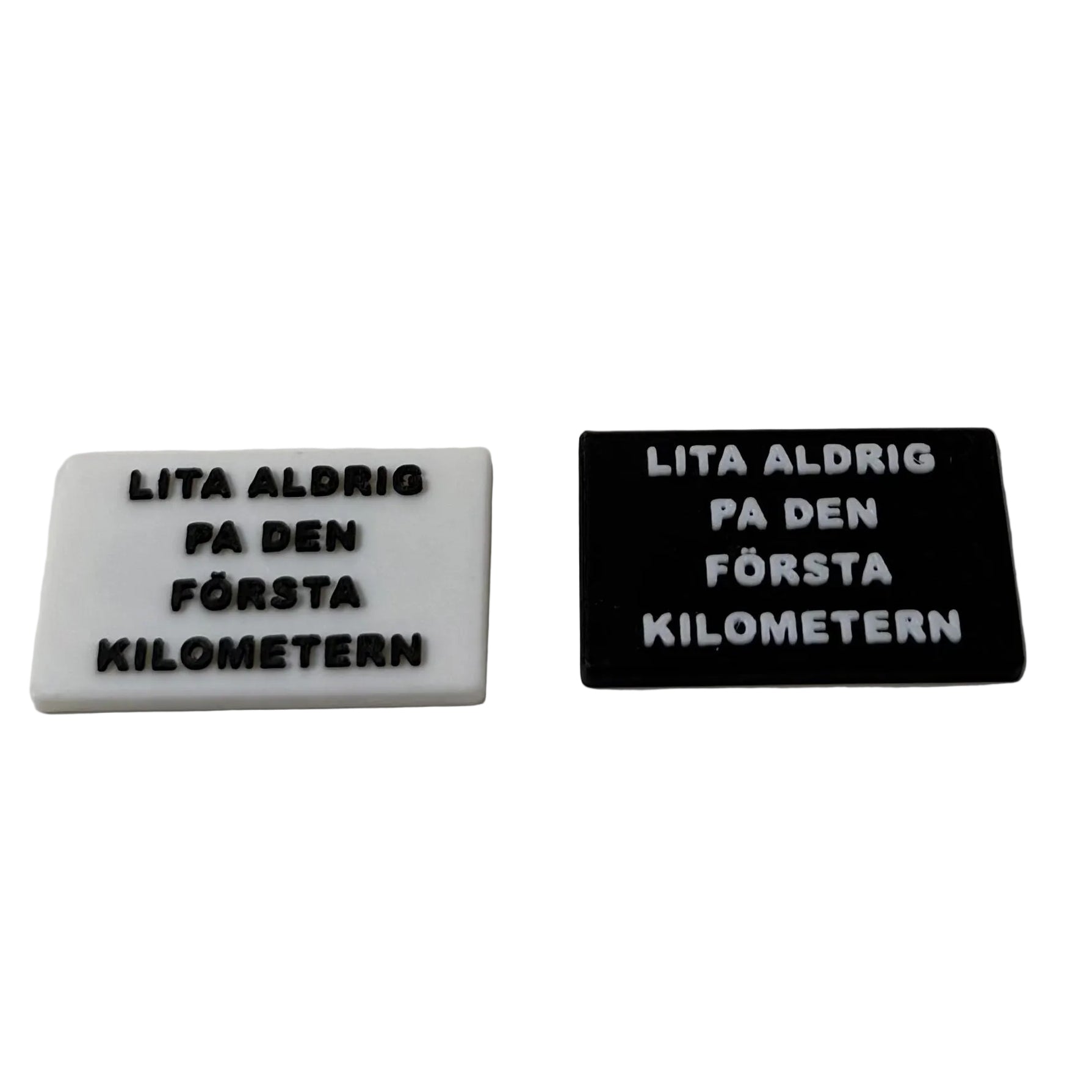 Bild på två olika kylskåpsmagneter med samma text